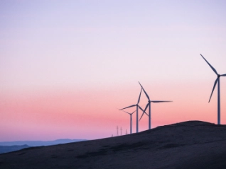 Wind turbines on a hillside at dusk