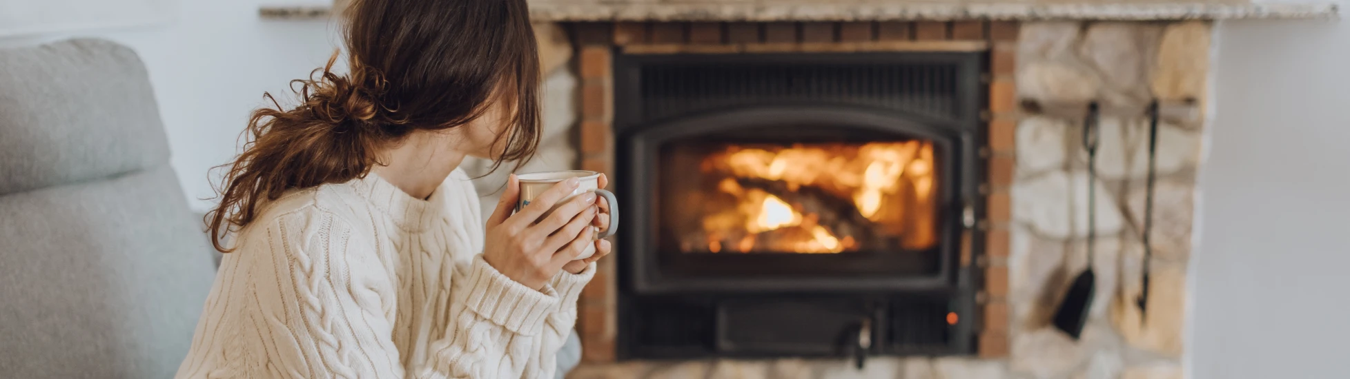 woman sat in front of a fireplace