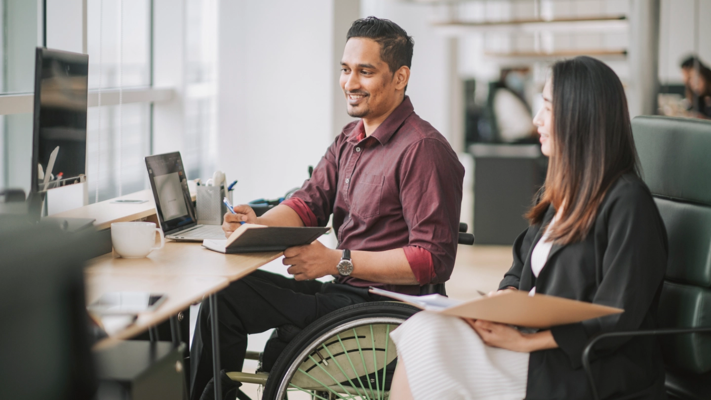 disabled man having a meeting with a woman colleague disabled man having a meeting with a woman colleague