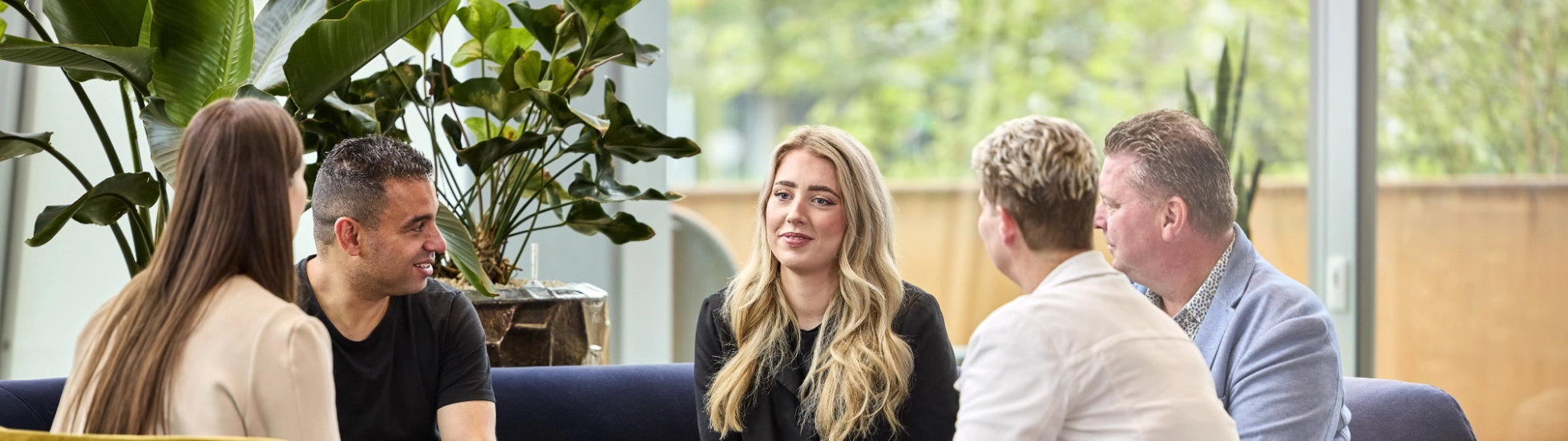 Two male and three female colleagues meeting in relaxed setting
