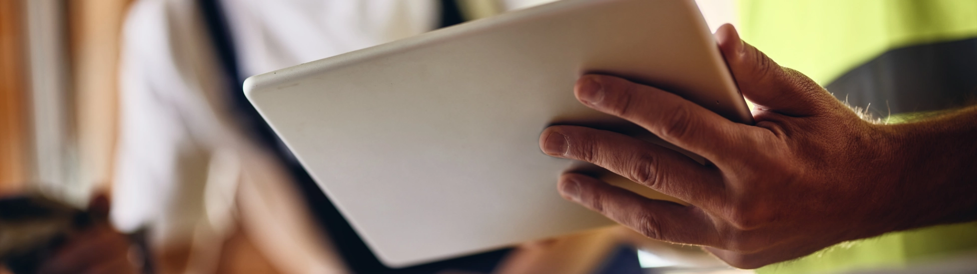 Two workers holding a tablet in a meeting on site