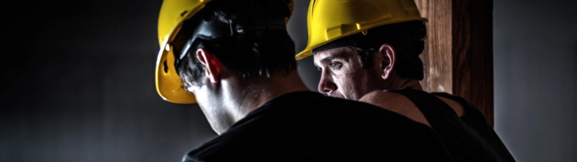 Two construction workers wearing yellow helmuts